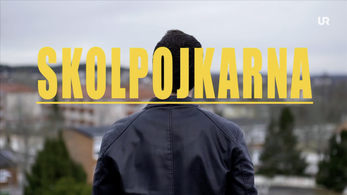 Vi ser en kille som blickar ut över en stad, staden är Karlskoga. Gul text stort över bilden; SKOLPOJKARNA