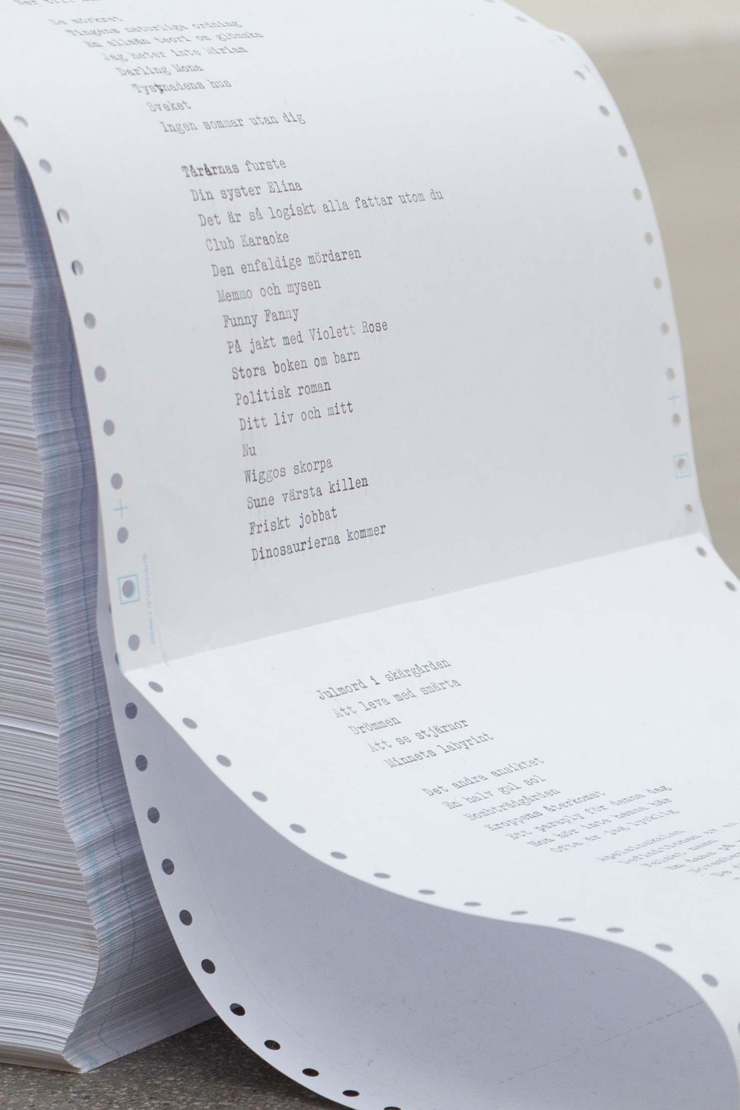 Installation av Ida Lindgren: skrivmaskin på vit sockel som skriver ut en lång remsa tabulatorpapper som faller ner på golvet.